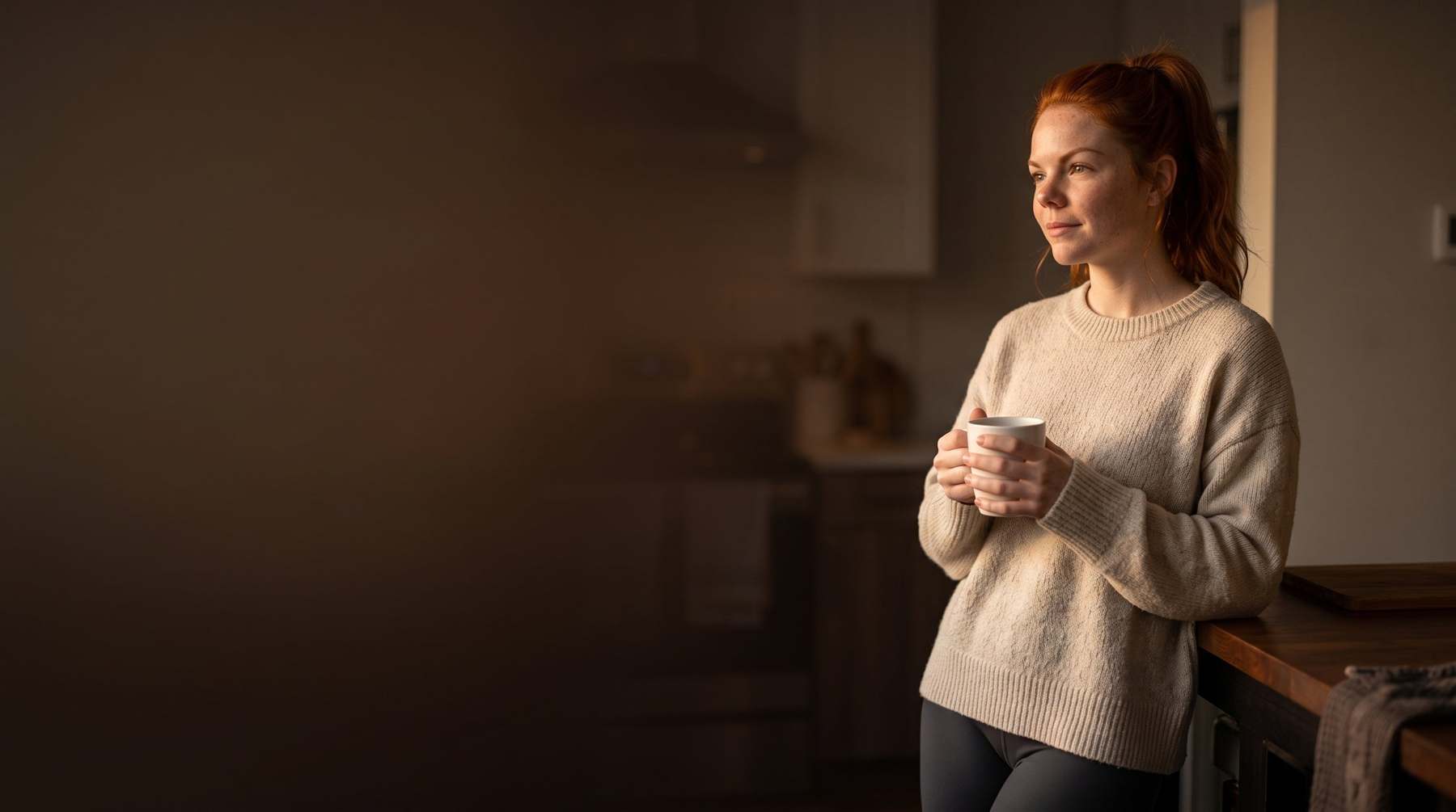 Woman pausing in her kitchen during her fasting window